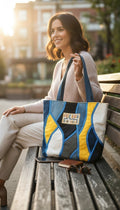 La Petite Fabrique de Maeva Sac fourre-tout patchwork en jean bleu, blanc, gris et jaune avec anses bleues. Patch "FREE HUGS".